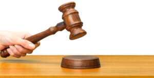 Judge’s gavel striking a wooden sound block, representing AI in the law.