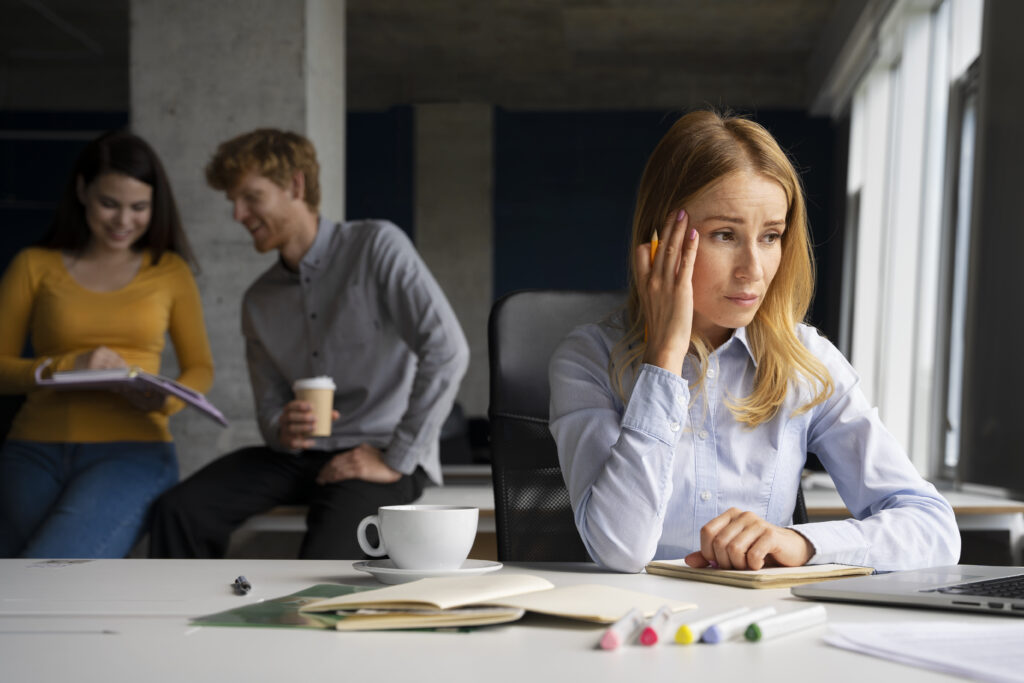 Worried woman at work considering an unfair dismissal claim after workplace mistreatment.