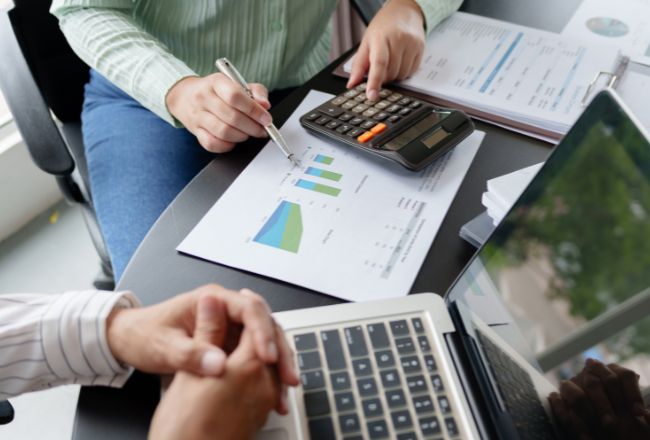 Financial advisor reviewing charts and calculations on property value report representing professional property valuation services.