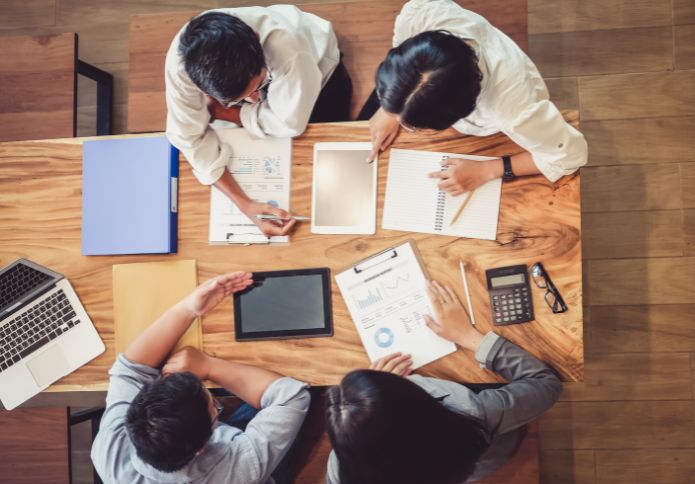 team meeting with documents and laptops – workplace bullying lawyer support and advice.